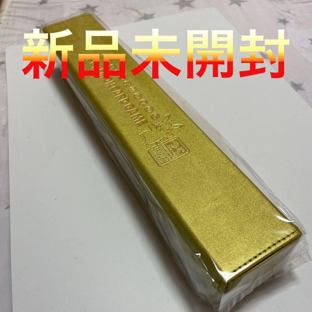 Gold Pokémon 25th playmat case in plastic packaging on a white surface.