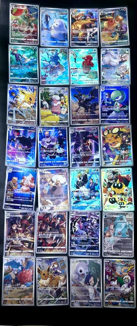 A grid of Pokémon trading cards in protective sleeves showing various holographic CHR cards on a dark background.