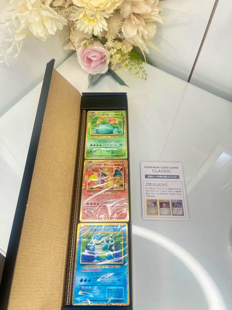 Unopened Pokémon Card Game Classic deck showing three holographic cards inside a long box with an information card beside it.
