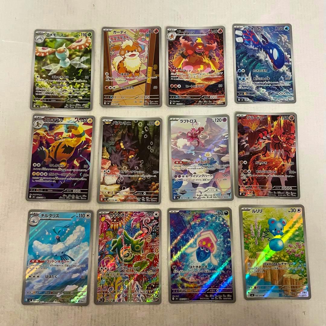Twelve Pokémon trading cards arranged in a 3x4 grid on a white background, showing various holographic artworks from the set.