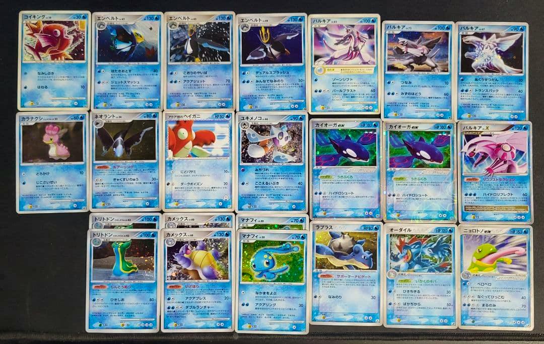 A laid-out assortment of water-type Pokémon trading cards photographed on a dark surface, showing multiple cards in rows.