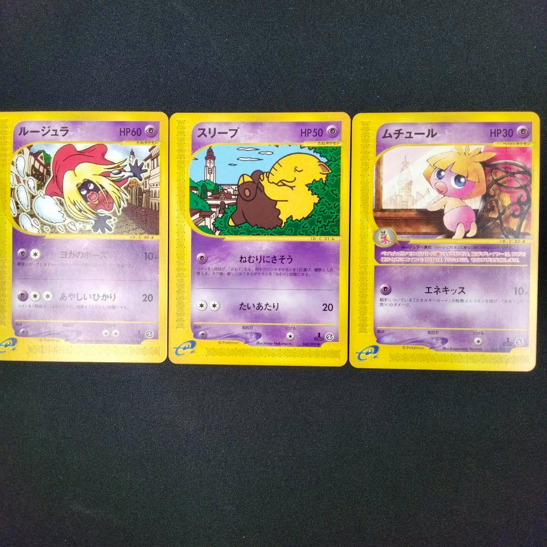 Three Pokémon trading cards (ルージュラ, スリープ, ムチュール) laid side by side on a dark background.