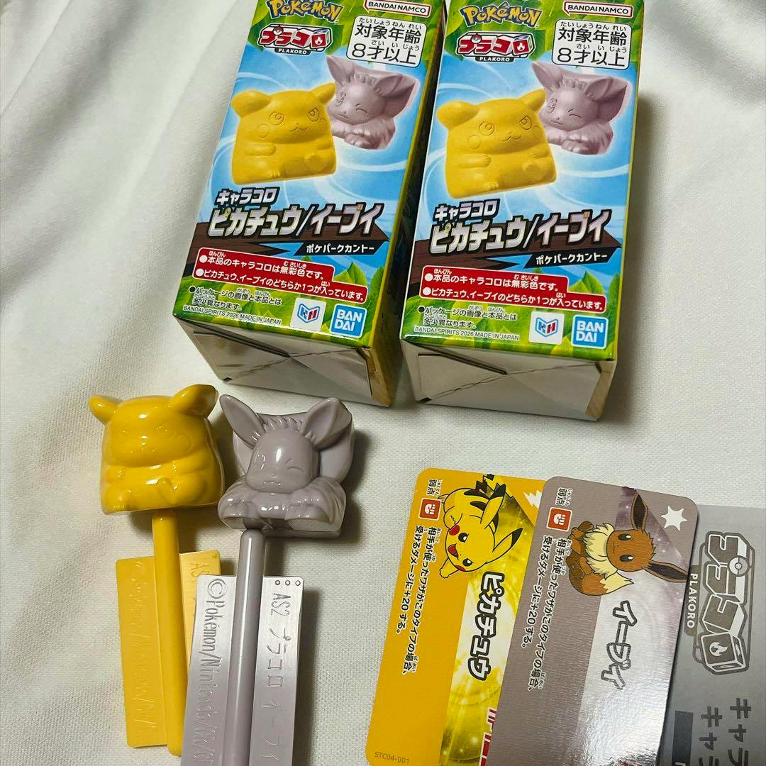Photo of the Pokémon Park limited Plakoro Pikachu and Eevee plastic figure set showing two boxed packages, two plastic figure sticks (Pikachu and Eevee), and character cards.