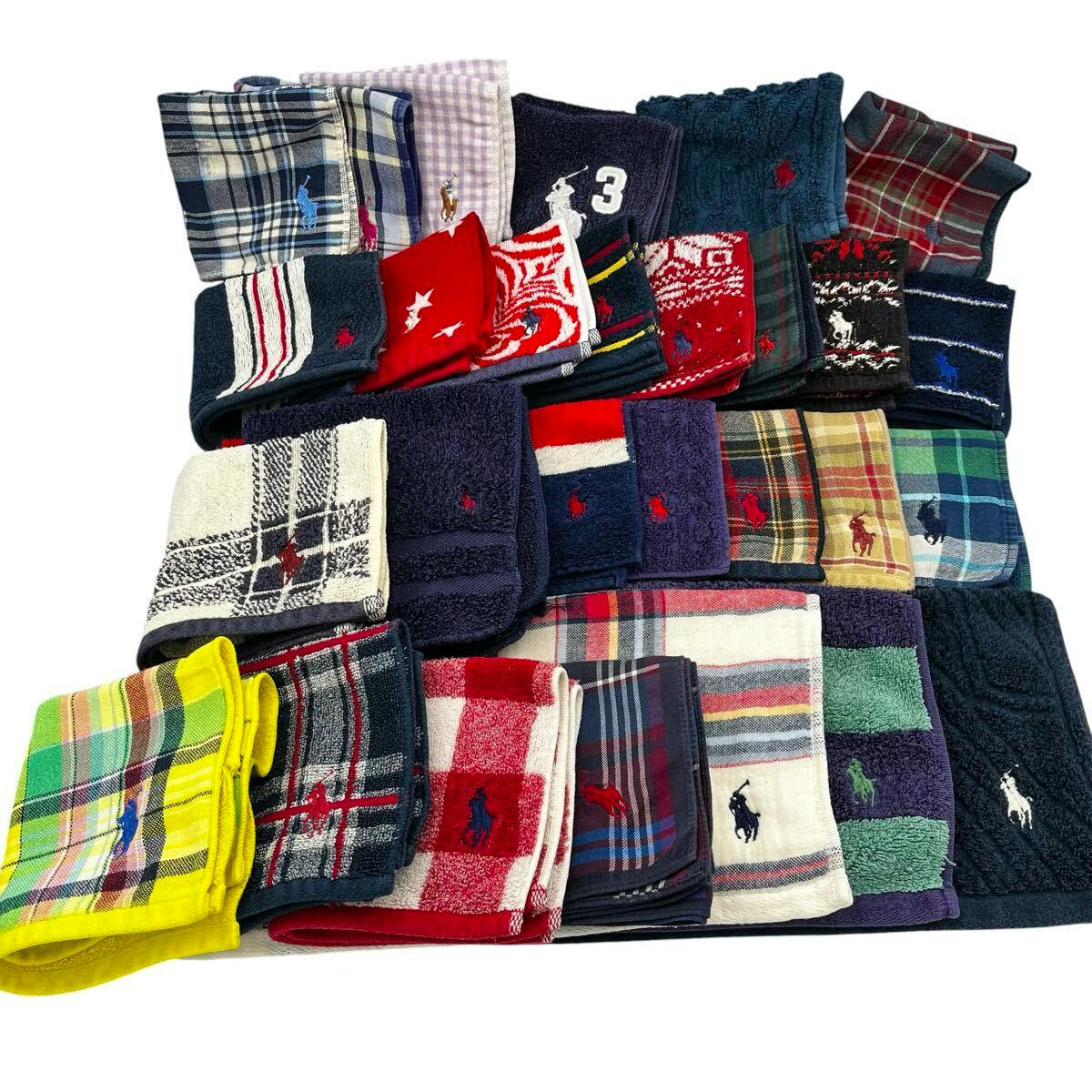 A spread of folded POLO Ralph Lauren hand towels and handkerchiefs in various colors and plaids, many showing the embroidered pony logo.