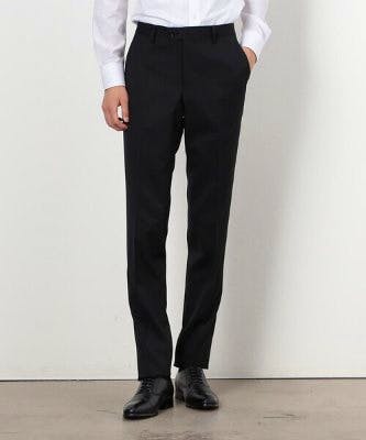 Front view of a model wearing black men's polyester wool gabardine pants against a white background.