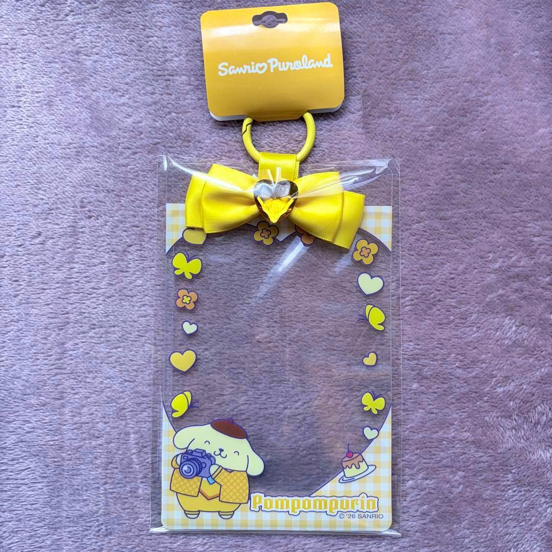 Front view of the Pompompurin plastic card holder (pass case) with a yellow bow and Pompompurin illustration at the bottom.