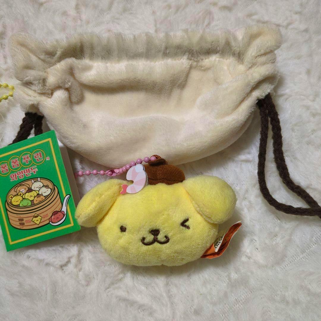 Front view of a yellow Pom Pom Purin plush mascot gyoza pouch and a beige drawstring pouch.