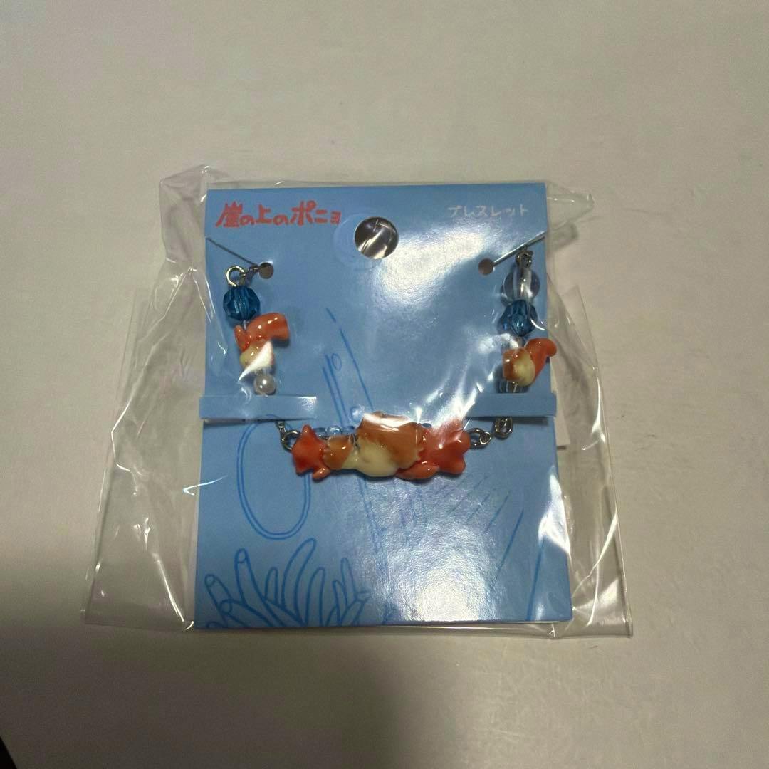 Packaged Ponyo-themed bracelet with small Ponyo charms displayed on a blue card inside clear plastic.