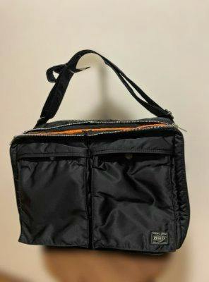 Front view of a black PORTER nylon shoulder bag with two front pockets and an adjustable strap.