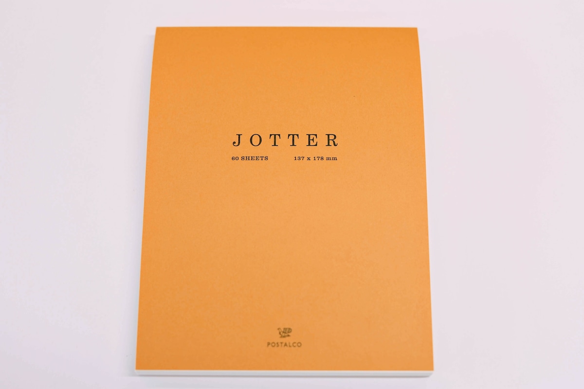 Orange POSTALCO Jotter notebook pad with 'JOTTER' printed on the cover on a white background.