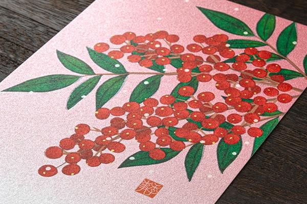 A postcard showing a printed nandina (南天) branch with red berries and green leaves on a pink background.