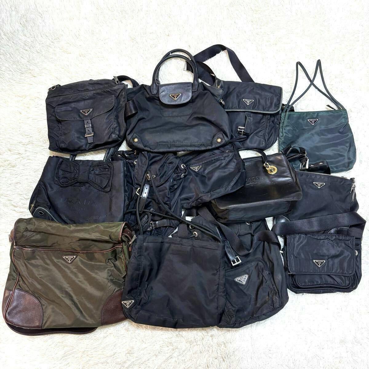 Multiple Prada nylon and leather bags laid out on a white surface, showing various shapes and visible triangle logo plates.