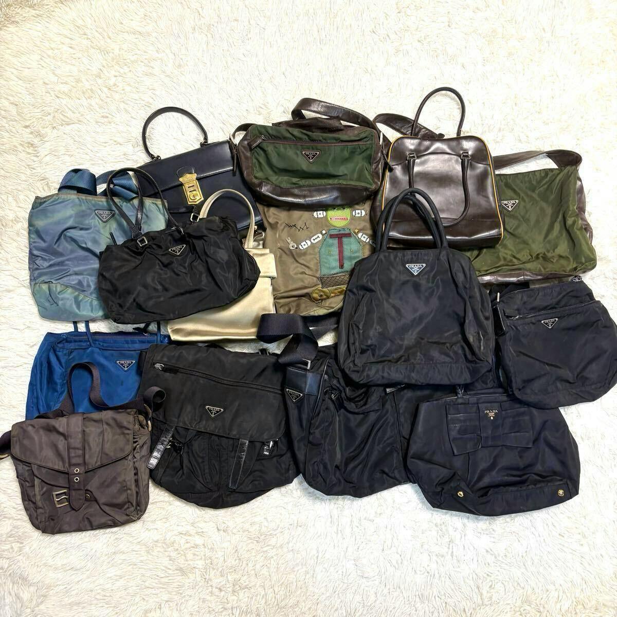 Multiple PRADA nylon and leather bags (shoulder, tote, handbag, messenger) arranged on a light rug showing triangular logos.