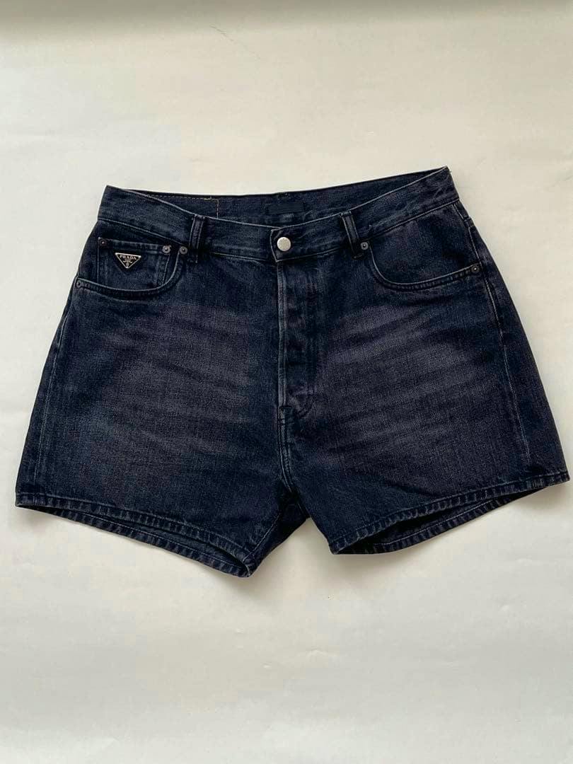 Front view of the Prada black denim men's shorts laid flat on a white background.