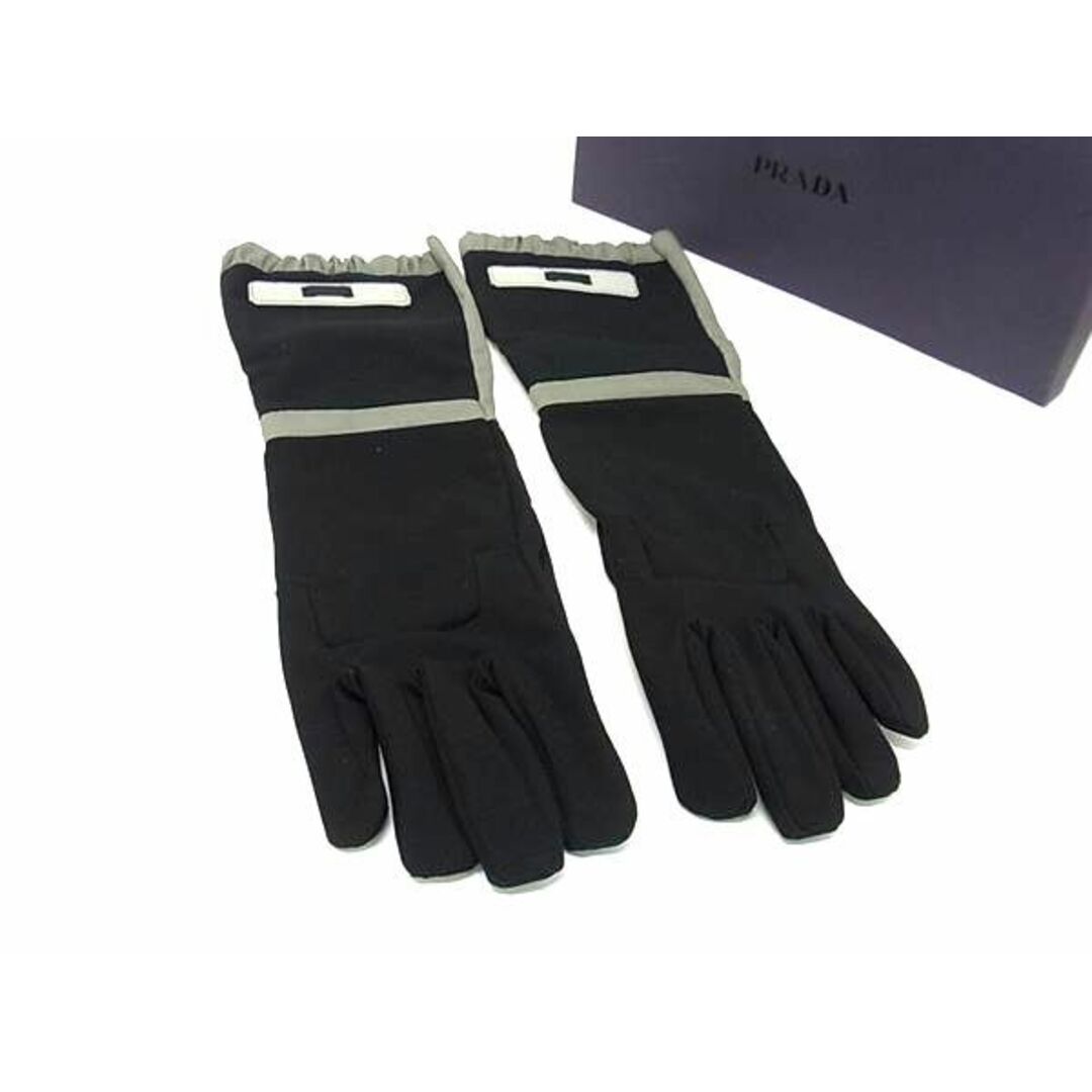 Long black-and-gray Prada gloves shown laid flat next to a Prada box.