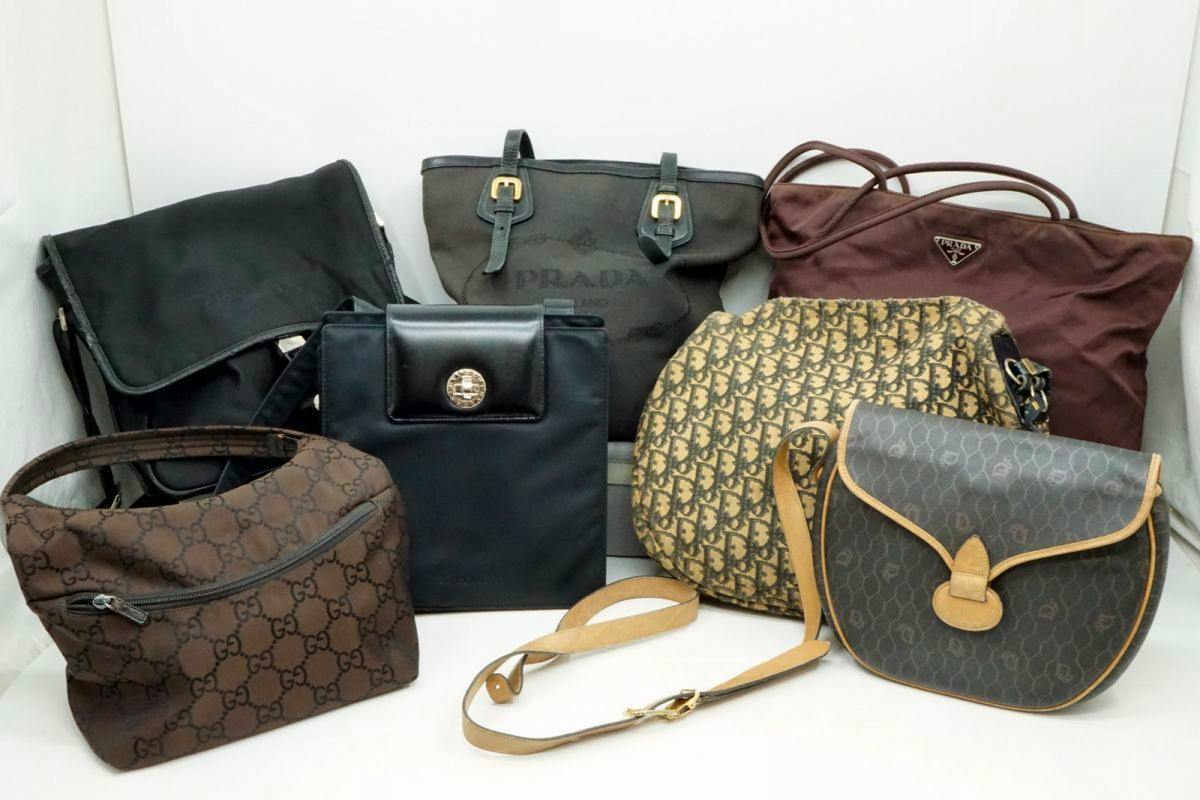 Seven assorted branded bags including Prada, Dior and Gucci displayed on a white background.