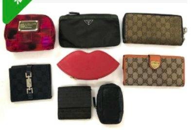 Top-down photo of eight wallets and small pouches arranged on a white surface, including patterned canvas pieces and a black pouch with a triangular logo.