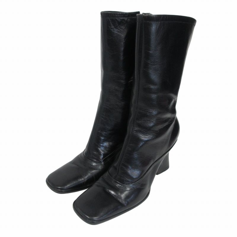 Pair of black leather mid boots with square toes shown from the front.