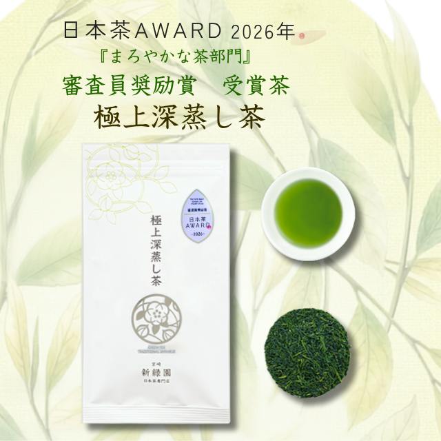 White package of the loose-leaf green tea shown next to a cup of brewed green tea and a small pile of loose tea leaves on a pale background with award text.