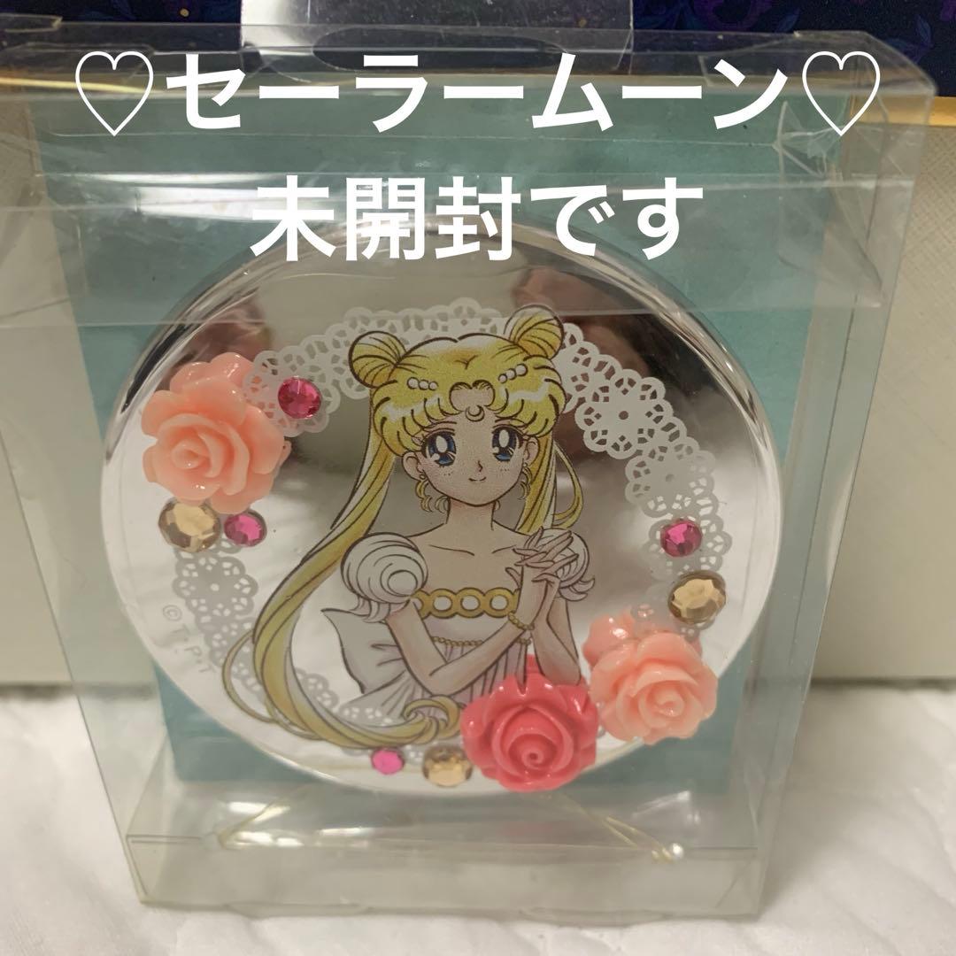 Compact mirror in clear plastic packaging featuring a Sailor Moon illustration with decorative roses and gem stickers.