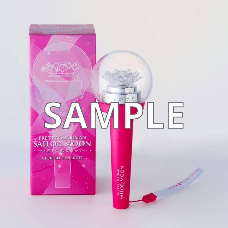 Pink Sailor Moon pen light standing next to its pink box with a detachable wrist strap visible.