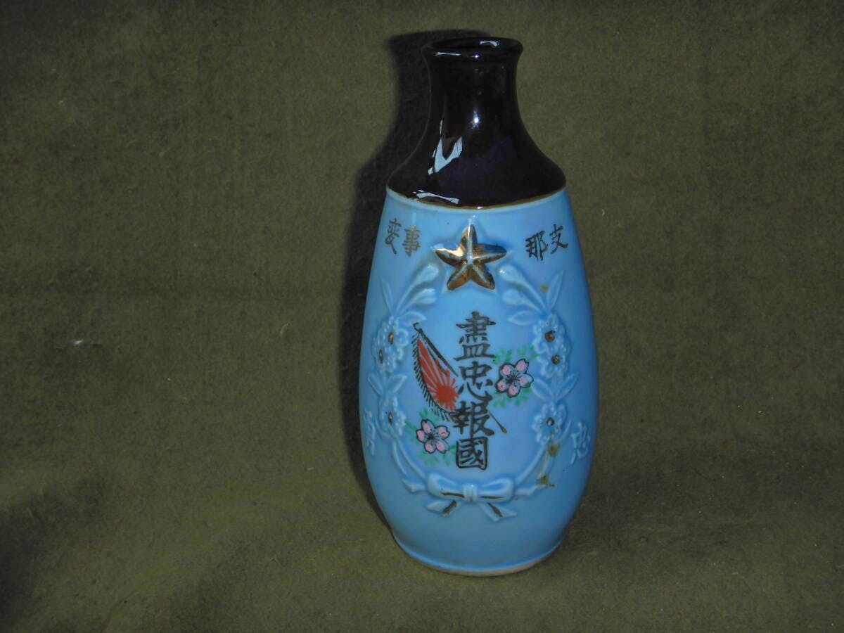 Blue ceramic flower vase showing Japanese characters and military motifs, including a rising sun flag.
