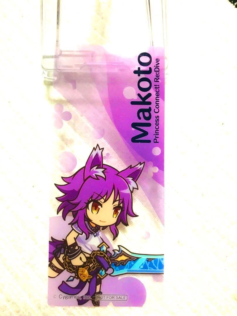 Plastic bookmark showing Makoto from Princess Connect! Re:Dive with purple hair and a sword on a purple background.