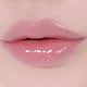 Close-up of lips wearing the lip gloss showing a glossy pink finish.
