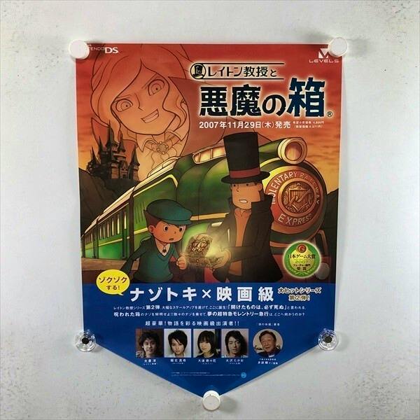 Photograph of the B3-sized "レイトン教授と悪魔の箱" poster showing illustrated characters and text, pinned to a wall.