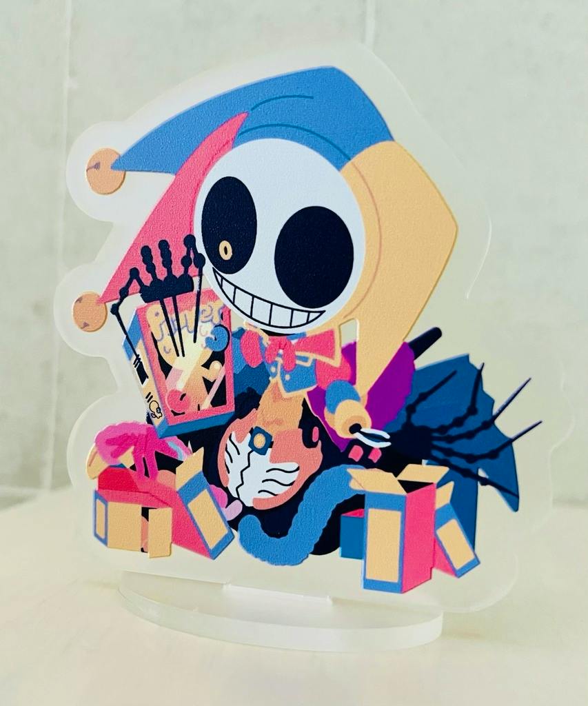 Photo of the acrylic decorative stand showing the printed colorful character artwork mounted in a clear acrylic piece inserted into a white oval base.
