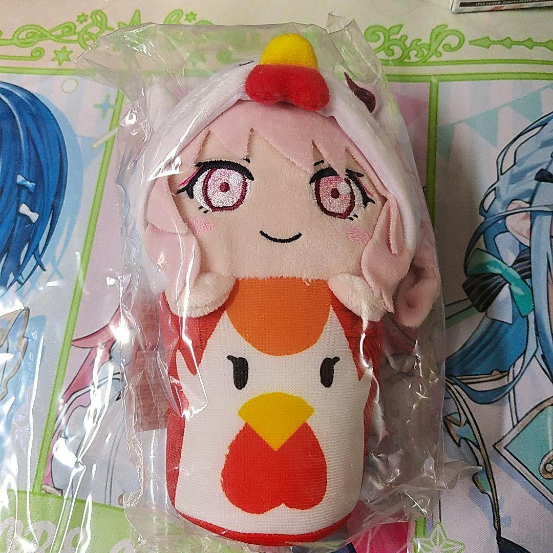 A Proseka plush of 暁山瑞希 dressed in a からあげクン chicken costume, shown inside clear plastic packaging on a patterned background.