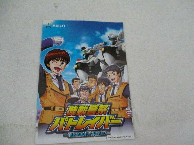 Front cover of the flyer for Mobile Police Patlabor showing series characters and a mecha against a blue-sky background.