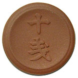 Round ceramic 10-sen coin showing the kanji characters "十銭" on its face.