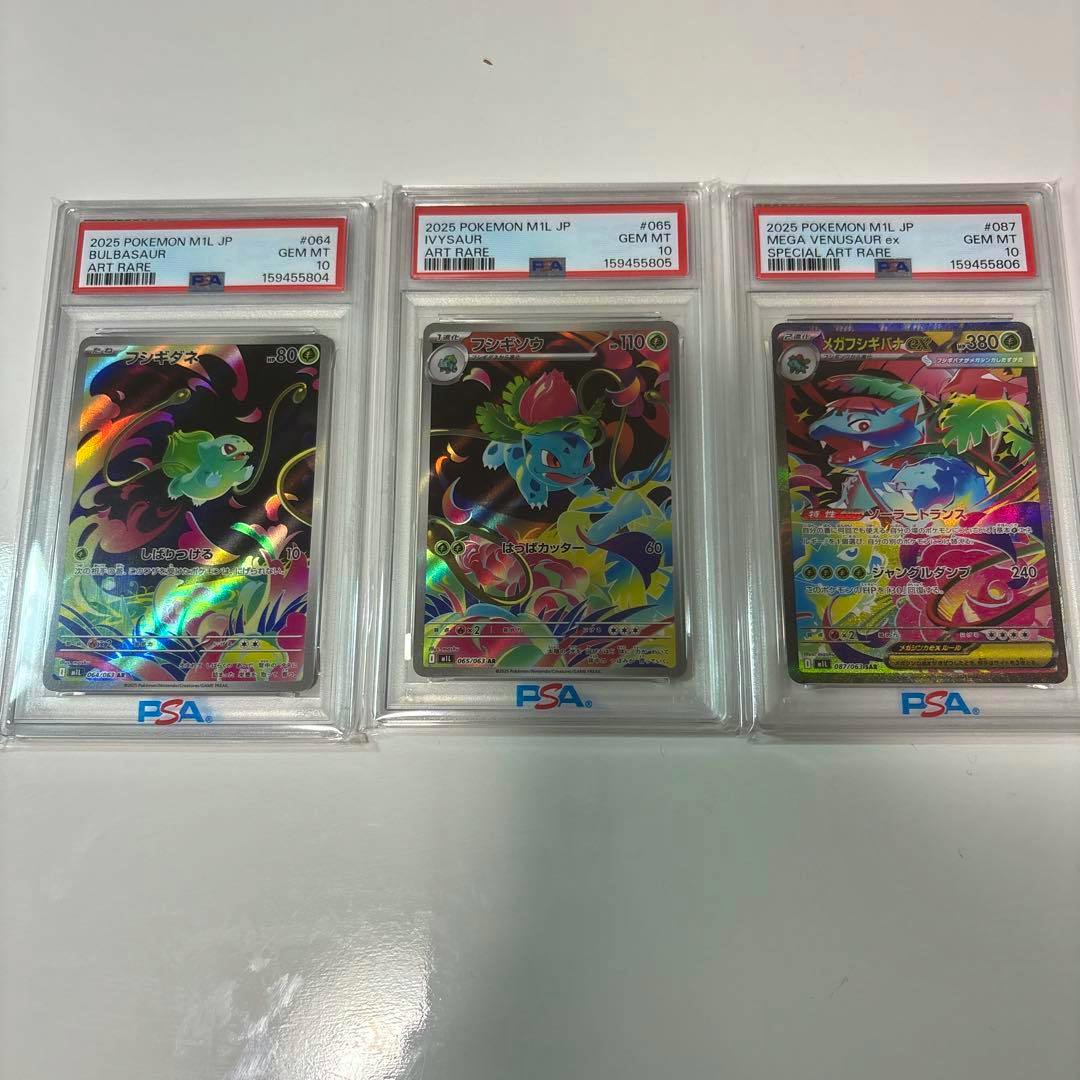 Three PSA-graded Pokémon trading cards (Bulbasaur, Ivysaur, Mega Venusaur ex) in plastic slabs displayed side-by-side on a white surface.
