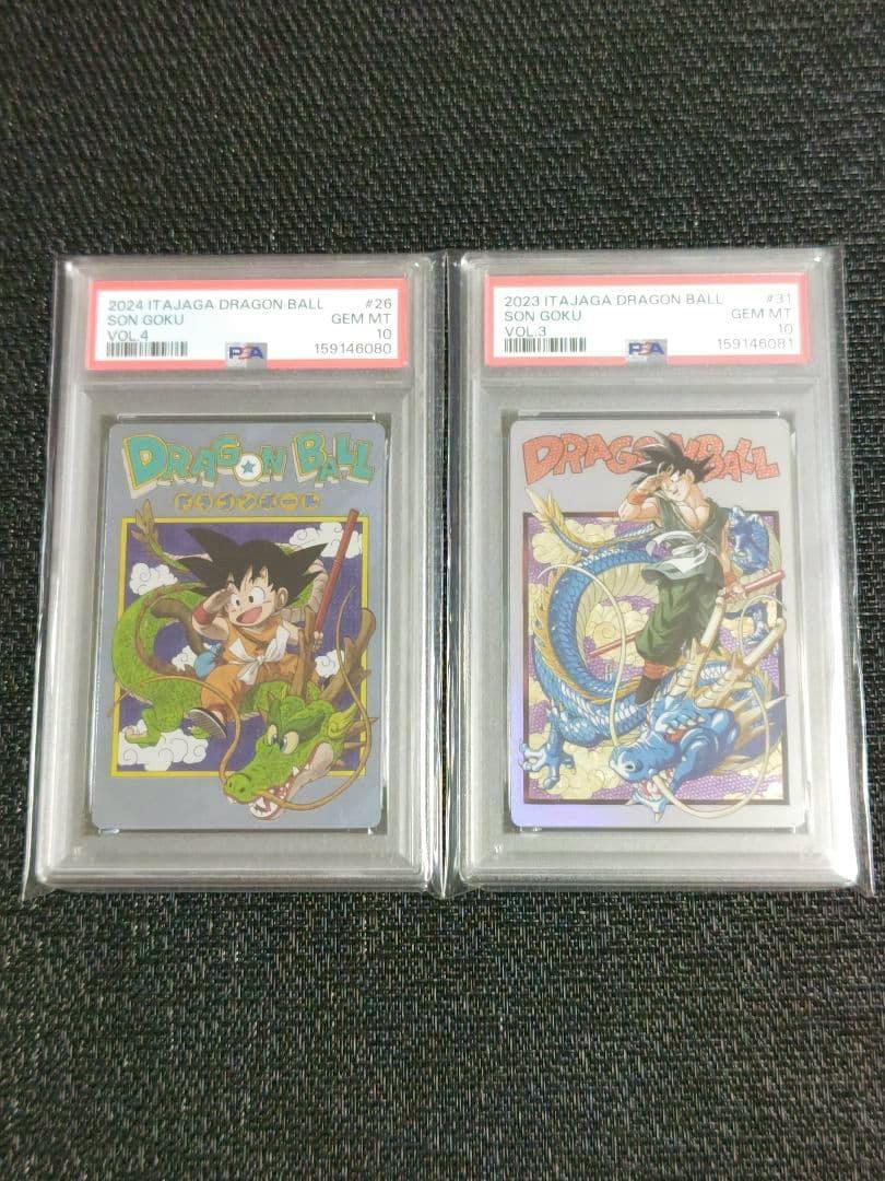 Two PSA-graded Dragon Ball trading cards in clear slabs showing front artwork of Son Goku and a dragon, side by side on a dark textured surface.