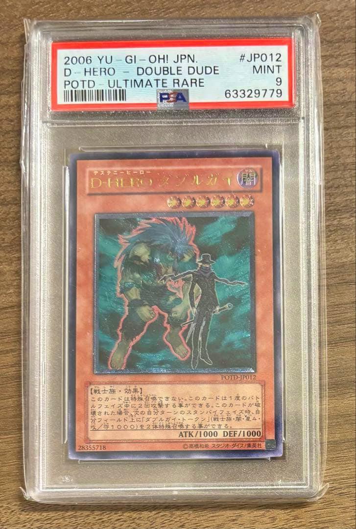 PSA-graded slab showing the Japanese D-HERO Double Dude (遊戯王) trading card with the PSA label visible.