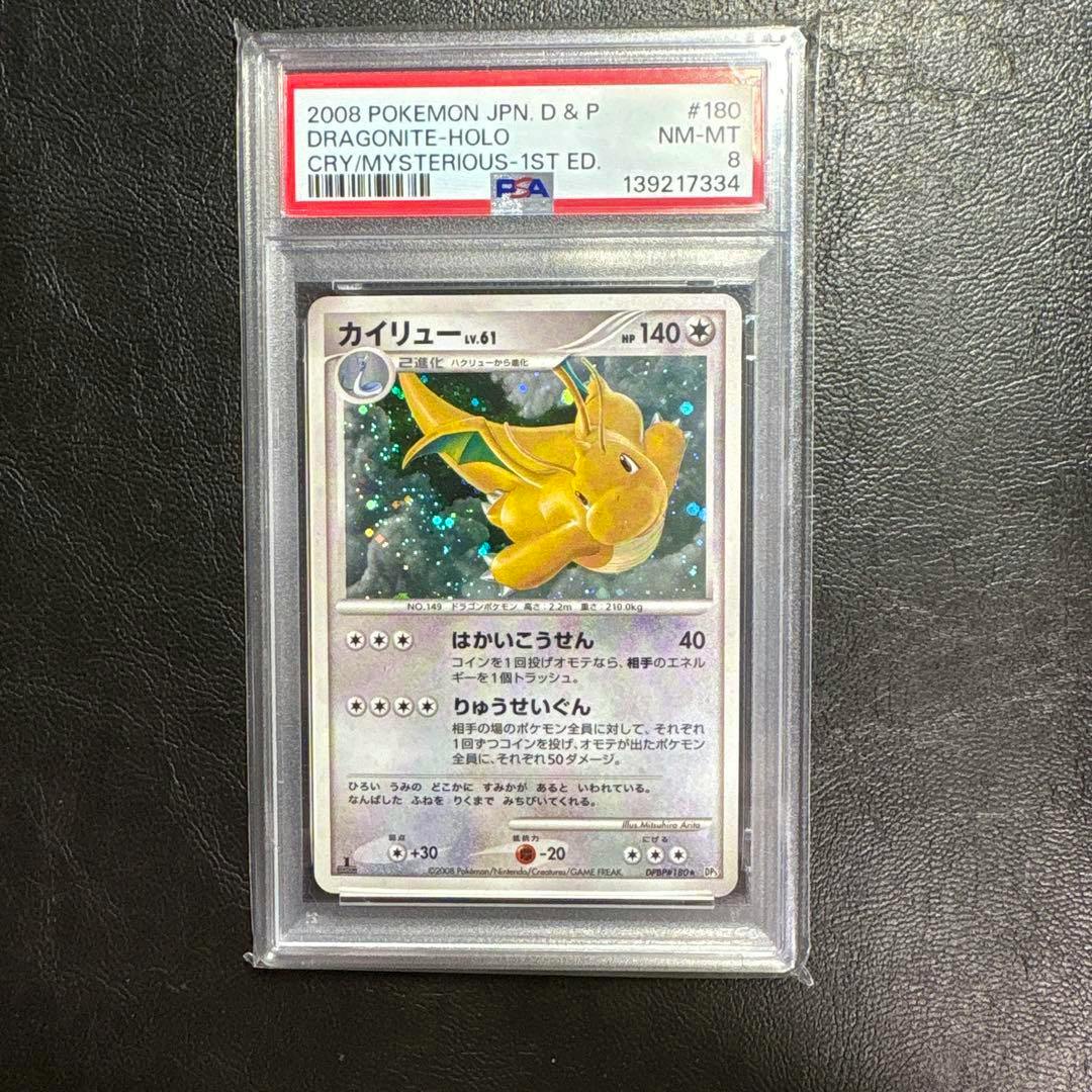 Front of the PSA98-graded Japanese Dragonite (カイリュー) holographic trading card visible in a clear PSA slab.