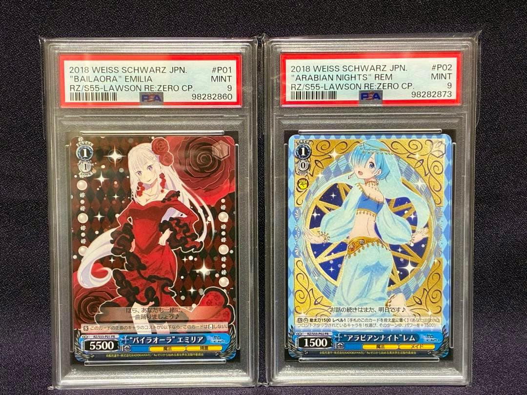Front view of two PSA-graded Weiss Schwarz trading cards in slabs showing Emilia on the left and "Arabian Nights" Rem on the right.