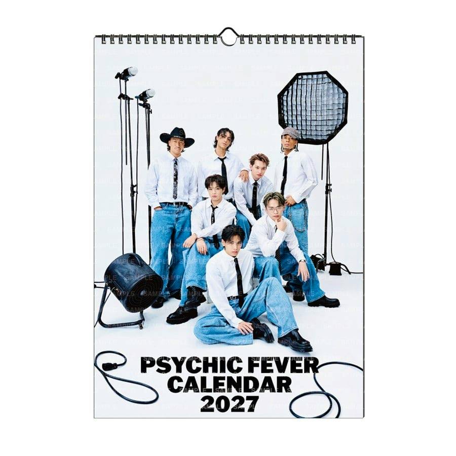 Wall-hanging PSYCHIC FEVER 2027 calendar showing a group photo of seven people in white shirts and jeans with studio lights and the title "PSYCHIC FEVER CALENDAR 2027" at the bottom.