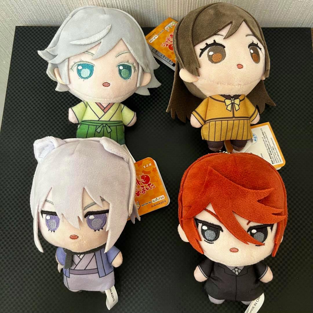 Four plush toys from "Kamisama Hajimemashita" arranged on a black surface, showing each character's face and outfit.