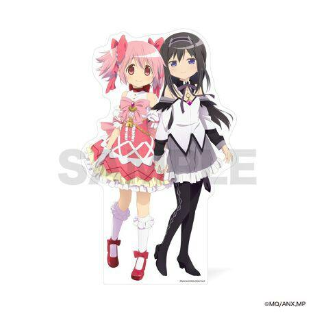 Life-sized panel standee showing two anime characters, Madoka Kaname in a pink outfit and Homura Akemi in a black-and-white outfit, standing side by side.