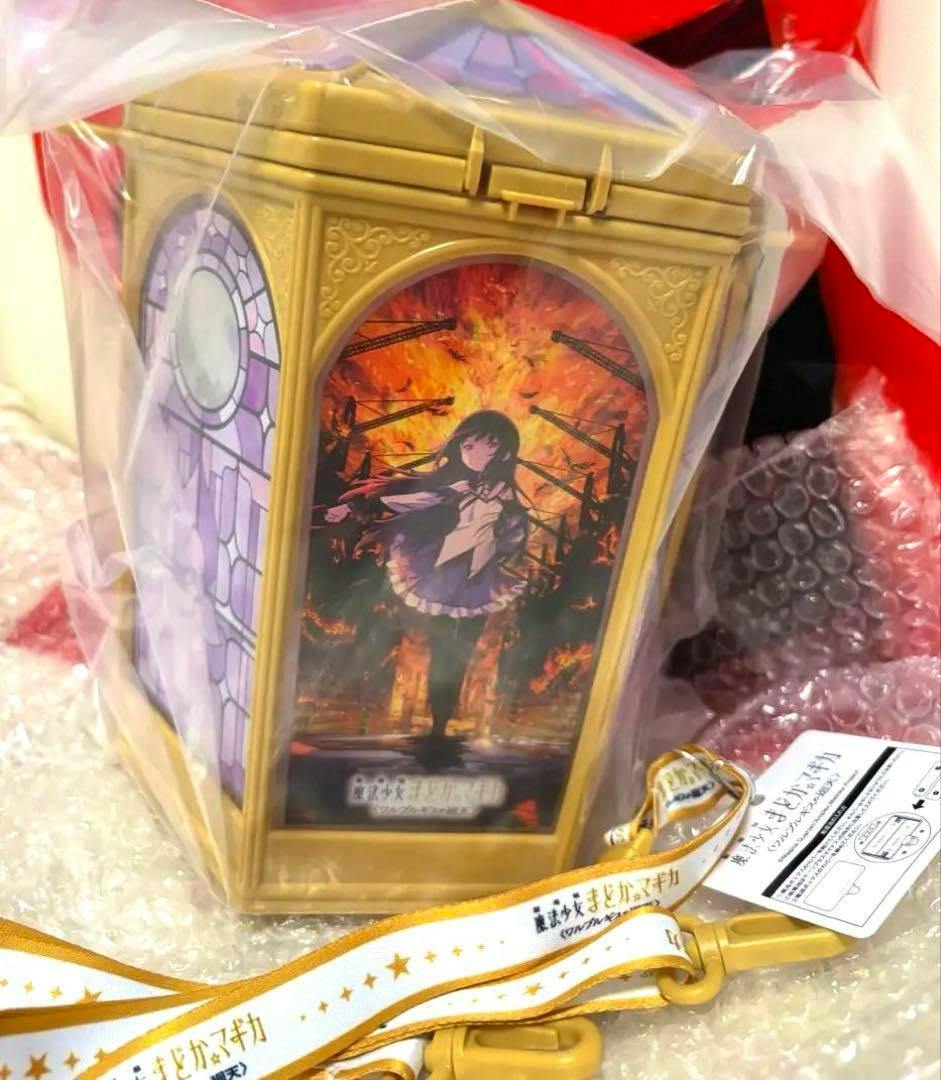 Gold plastic Madoka Magica 'Walpurgis' popcorn bucket in plastic wrap showing character artwork and attached lanyard and tag.