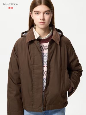A model wearing the women's short jacket in brown with a collar and front pockets.