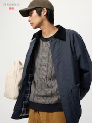 A person wearing the jacket in a dark color with a contrasting collar, shown open over a sweater.