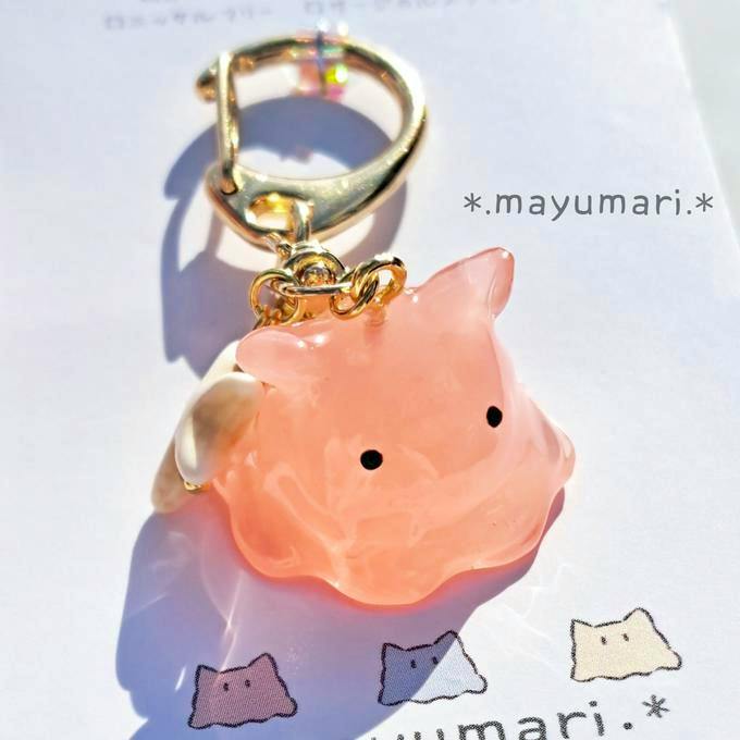 Close-up of the pink plastic keychain charm (ぷくりちゃん) with a small starfish attached and a gold-colored clasp on a white backing card.