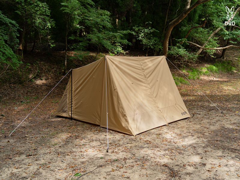Beige polyester front panel mounted on a small A-frame tent set up in a wooded clearing.