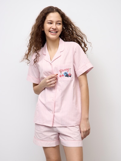 A model wearing pink short-sleeve cotton pajama top and matching shorts.