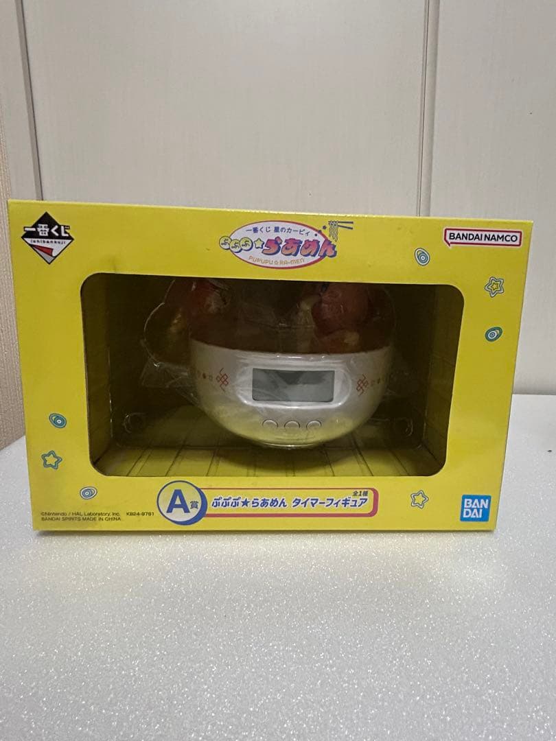 A kitchen timer figure visible inside its yellow windowed retail box.