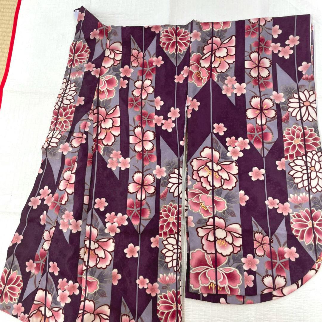 Purple and pink floral polyester women's kimono laid flat showing the full patterned fabric.