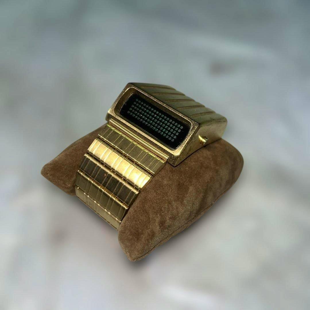Gold R'POLICE digital wristwatch shown on a brown display cushion.
